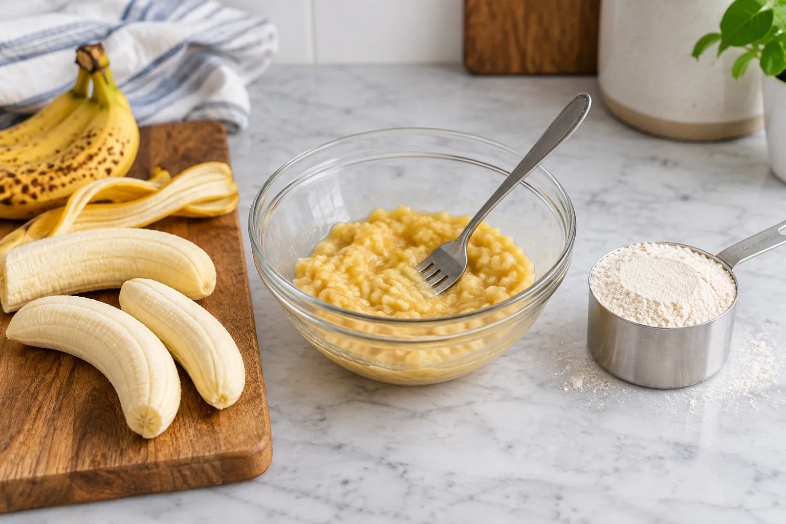 Ripe bananas, fork-mashed fruit and a leveled measuring cup